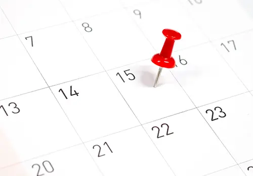 red pin on a calendar on the 15th