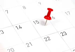 red pin on a calendar on the 15th
