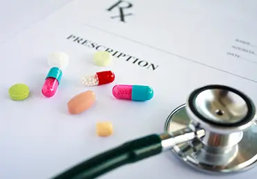 Pills and stethoscope on a prescription