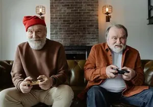 Two elderly gentlemen play video games together during retirement.