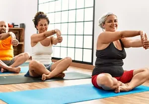 Group of middle age people stretching at sport center.