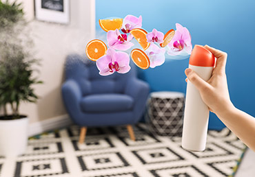 An woman sprays a citrus-flowered air freshener. But is it safe?.