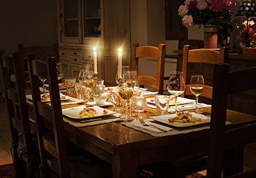 A dinner table is set by candelight.