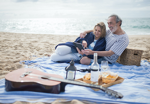 Older couple having picnic on beach.