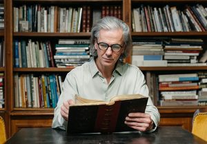 A man sits at a table to read at the library.