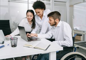 A group of people read an article mentioning "medicare expands coverage for wheelchair users."