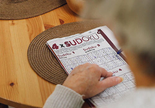 Older woman plays sudoku.
