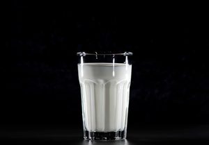A glass of magnesium-rich milk is seen against a black background.