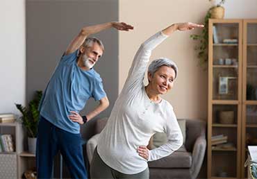 senior couple being active by exercising at home