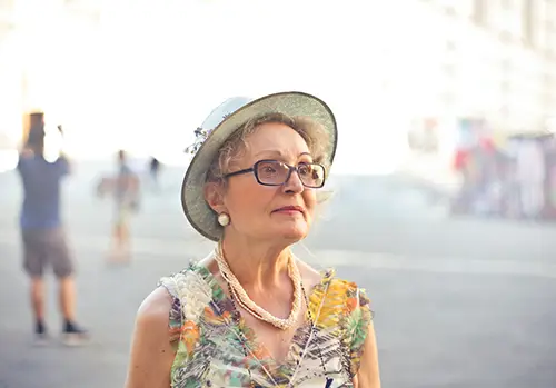 An older lady poses for a photograph and looks offscreen.