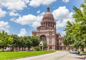 The Texas state capitol is photographed on a cloudy day.