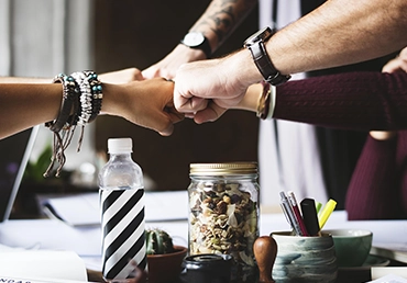 a team from a small business fist bumping