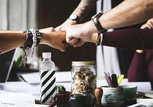 a team from a small business fist bumping