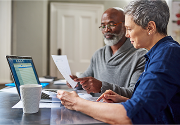 a senior couple busy on reviewing documents in the home together.