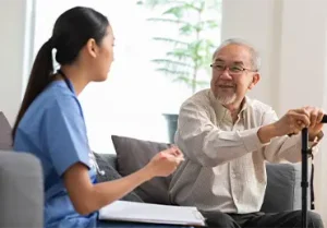 Elder man talking with young woman nurse about Medicare open enrollment tips