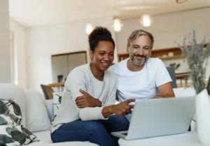 Senior couple looking happy, using a laptop.