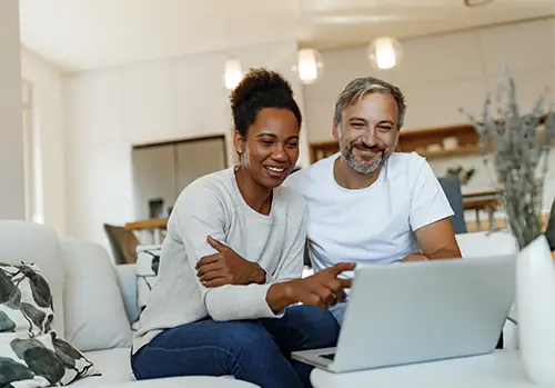 Senior couple looking happy, using a laptop.