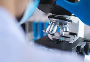 Scientist examining liquid biopsy under microscope