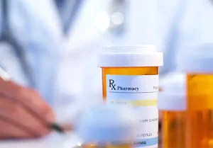Prescription drug bottle on table with pharmacist in background