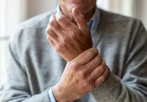 Senior man with arthritis rubbing hands