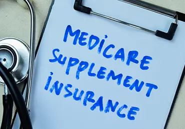 Clipboard with stethoscope on top, text reads "Medicare Supplement Insurance"